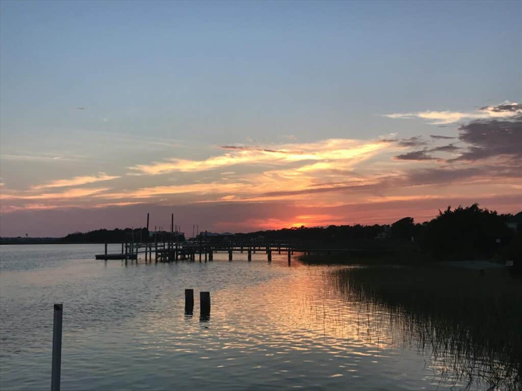 A beautiful sunset at a dock in Myrtle Beach, capturing the reflection on calm waters.