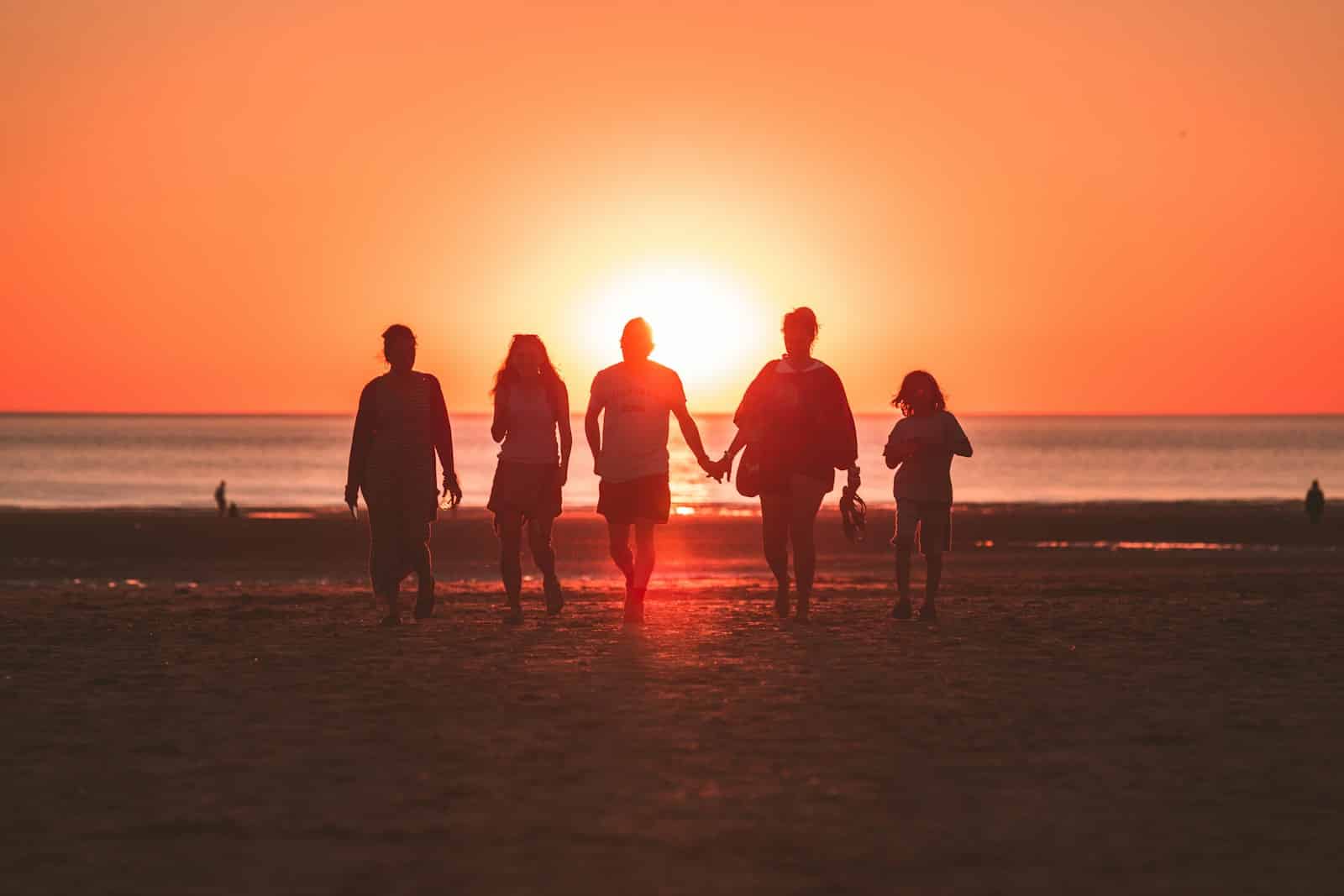 silhouette photo of five person walking on seashore during golden hour top things to do in myrtle beach for families