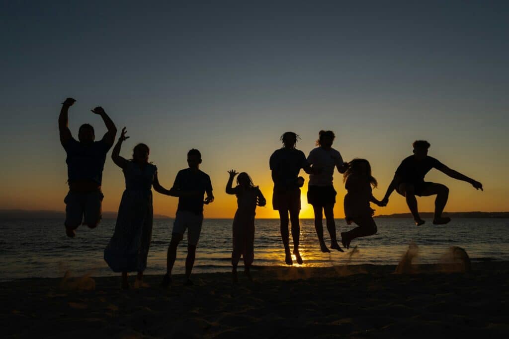 a group of people standing on top of a sandy beach