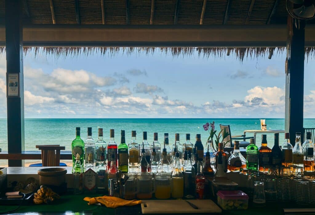 a bar with bottles of alcohol on the beach