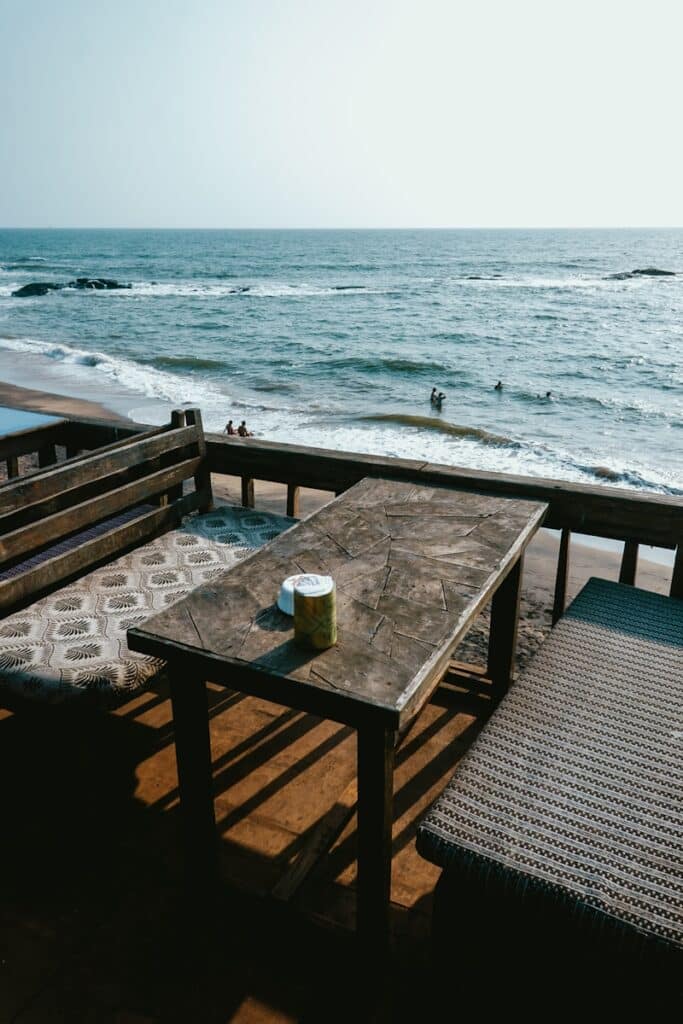 jar on table with bench near ocean