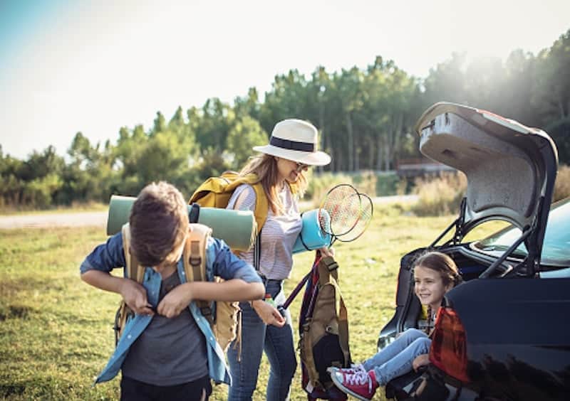 Happy Family Enjoying picnic and Camping Holiday In Countryside