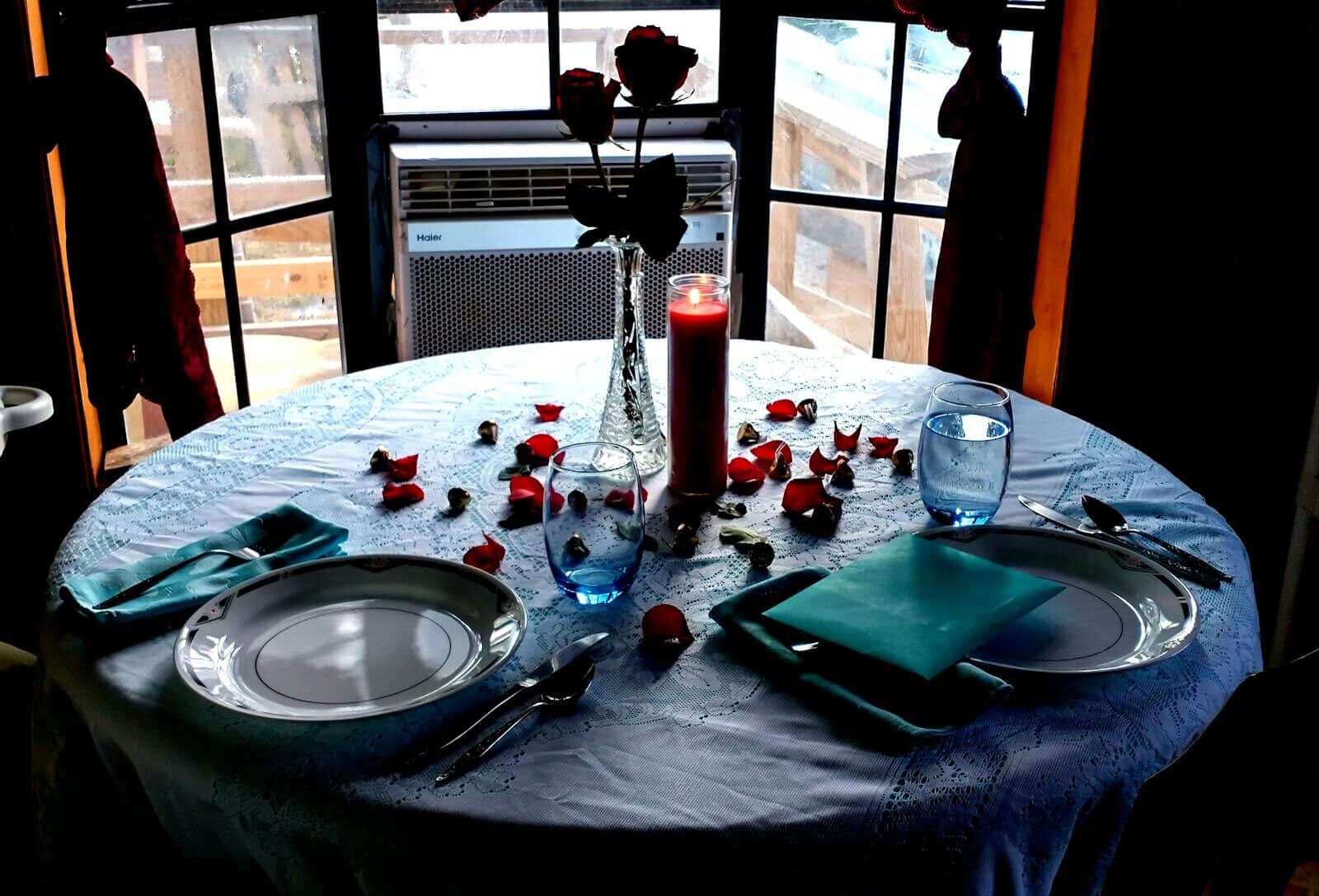 A beautifully set table with a candle and rose petals, creating an intimate ambiance. Dinner Shows Myrtle Beach: Enjoy with Family and Friends