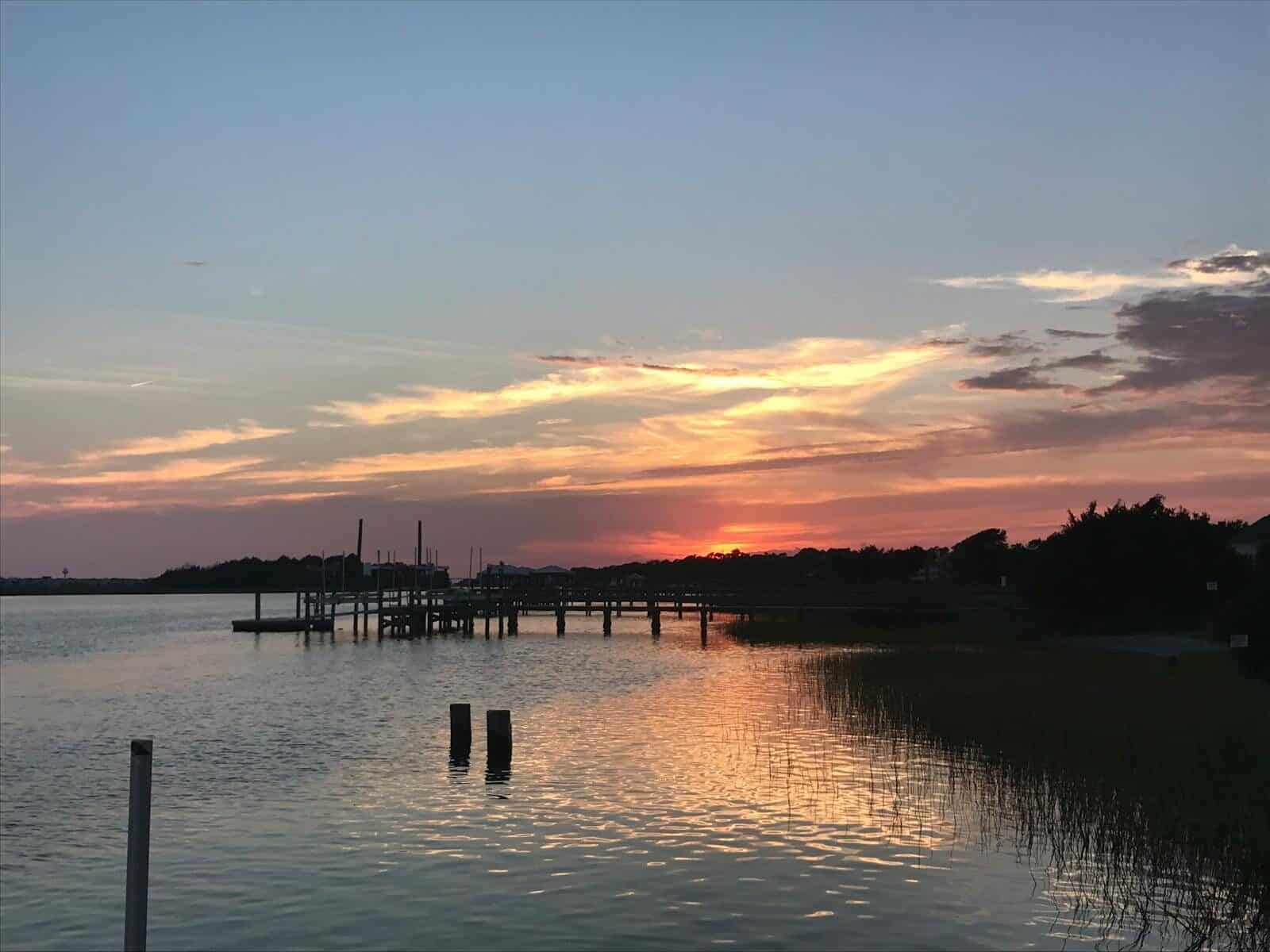 A beautiful sunset at a dock in Myrtle Beach, capturing the reflection on calm waters. The Ultimate Guide to Things to Do in Myrtle Beach for Adults