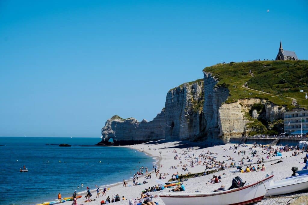 a group of people on a beach next to a body of water