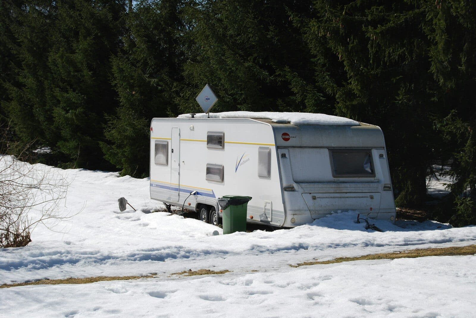 a trailer parked in the snow next to a forest Do You Need RV Winterization Services in Myrtle Beach? Here’s Why You Might