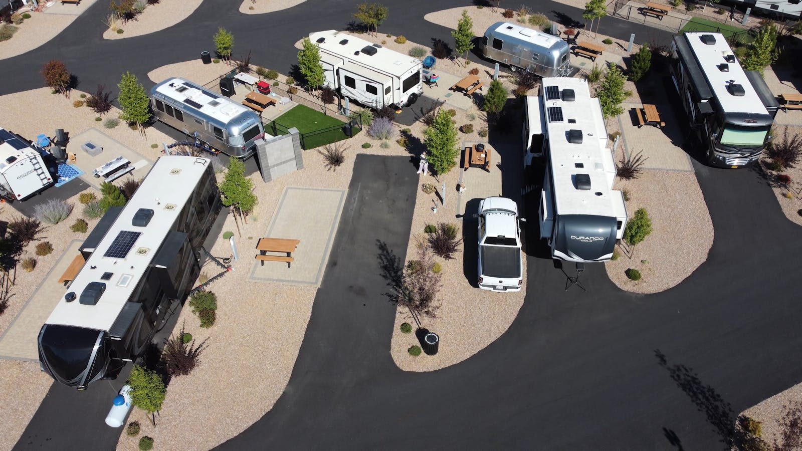 A scenic aerial shot showing a modern RV park with various campers and trailers.