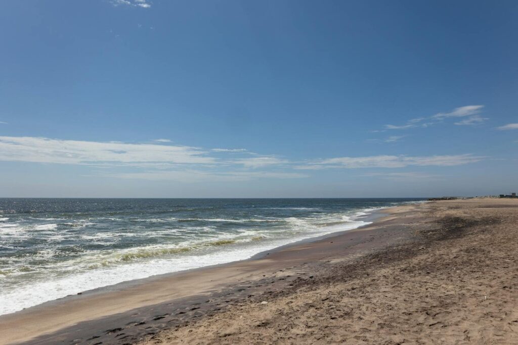 Stunning coastline view in Namibia with sandy beach and clear blue sky, perfect for travel and nature themes.
