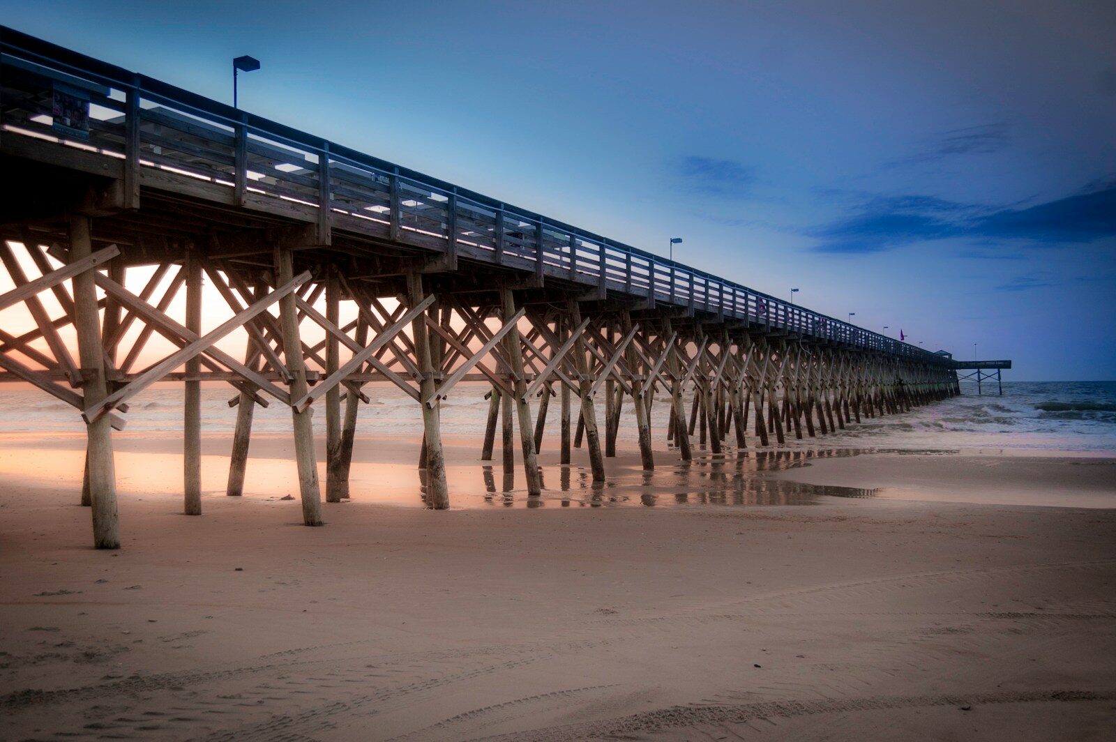 a long pier stretches out into the ocean