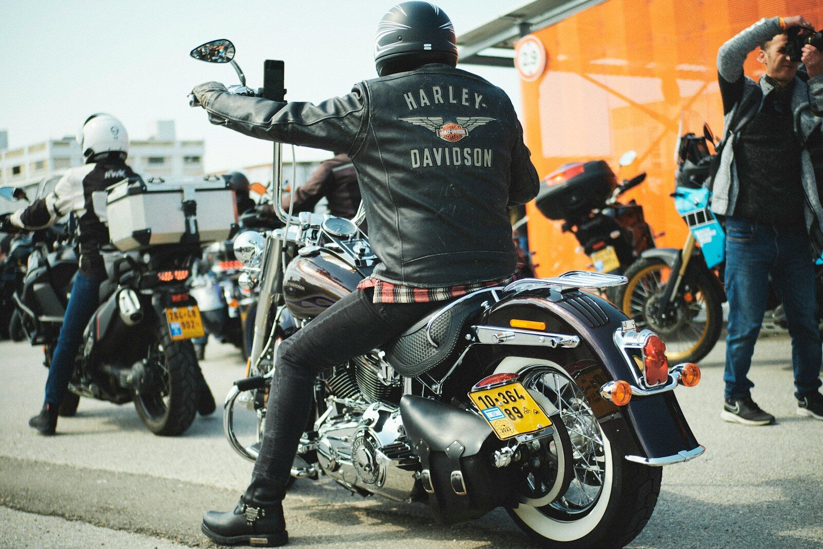 a man sitting on a motorcycle in a parking lot