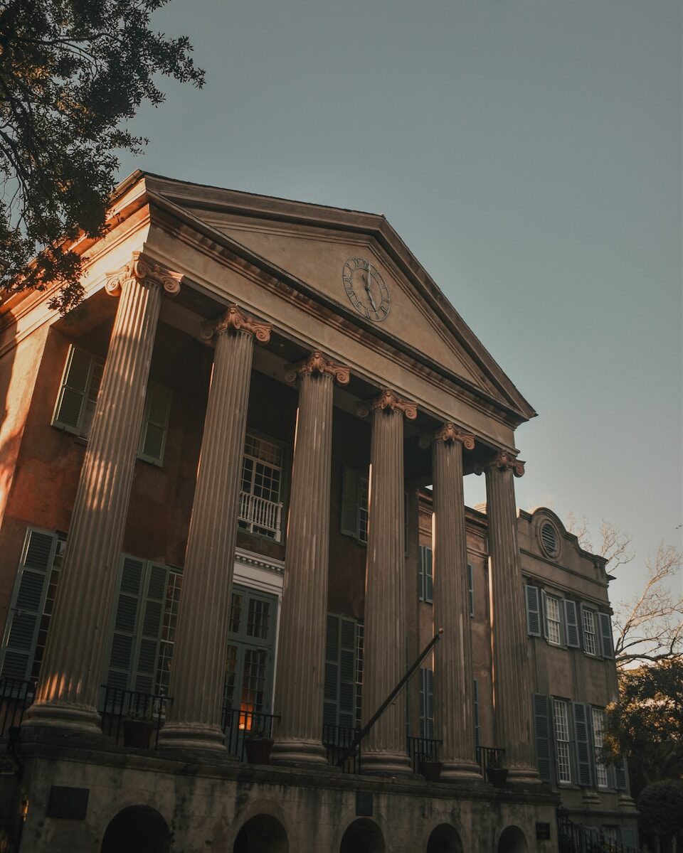 a large building with columns and a clock on the front