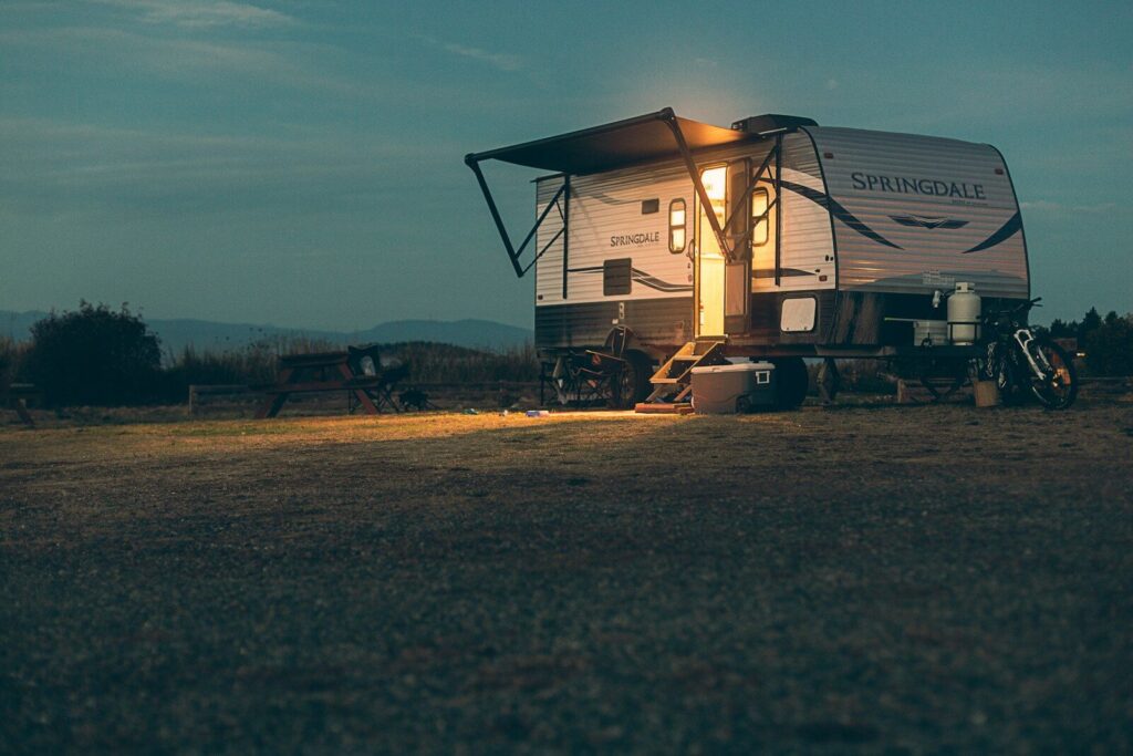 a small camper sits in a field at night