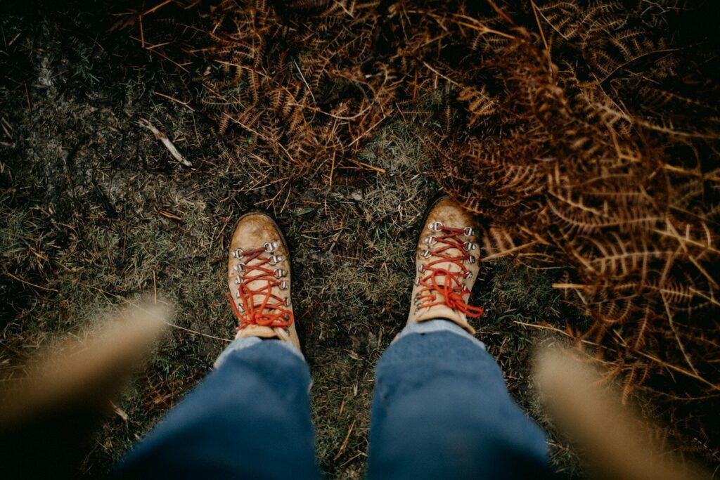 a person standing in the grass with their feet on the ground