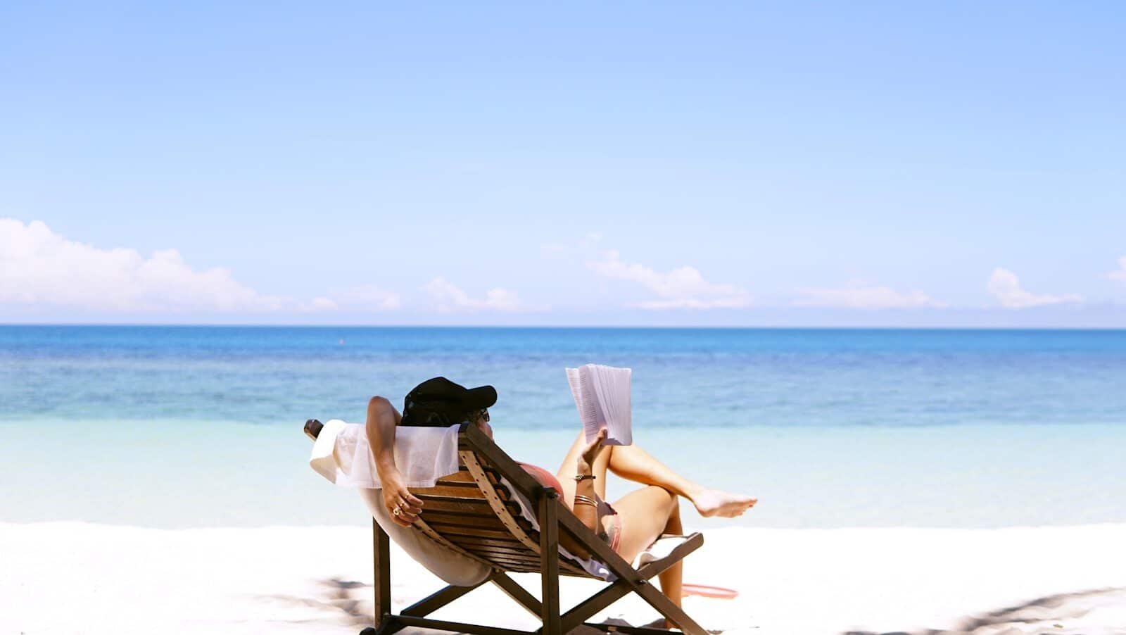 woman sits on brown wooden beach chair The Ultimate Packing List for Beach Vacation in Myrtle Beach